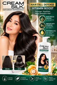 Cream Silk Hair Fall Defense Vitamin Boost Conditioner with Pro-Vitamin B5 and Marula Oil, displayed beside a woman with long, glossy black hair. Green and gold promotional background with hair care benefits and product bottle.